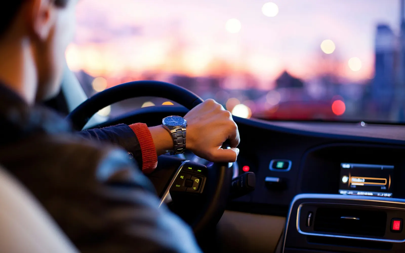 Chauffeur au volant d'une berline le soir, en mise à disposition pour un client