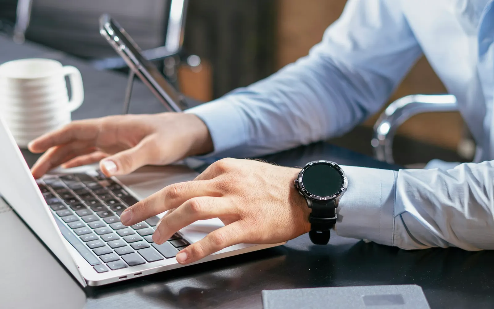 Mains sur un ordinateur portable, au bureau d’une entreprise de transport, pendant le suivi des factures