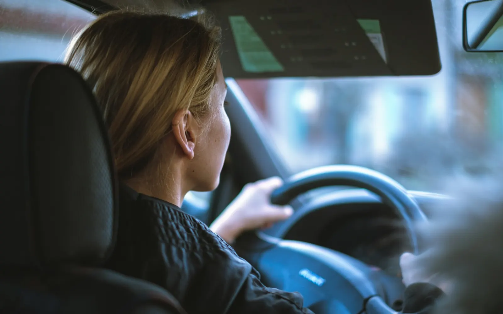 Conductrice au volant entre deux courses, dans une journée organisée grâce au planning des chauffeurs