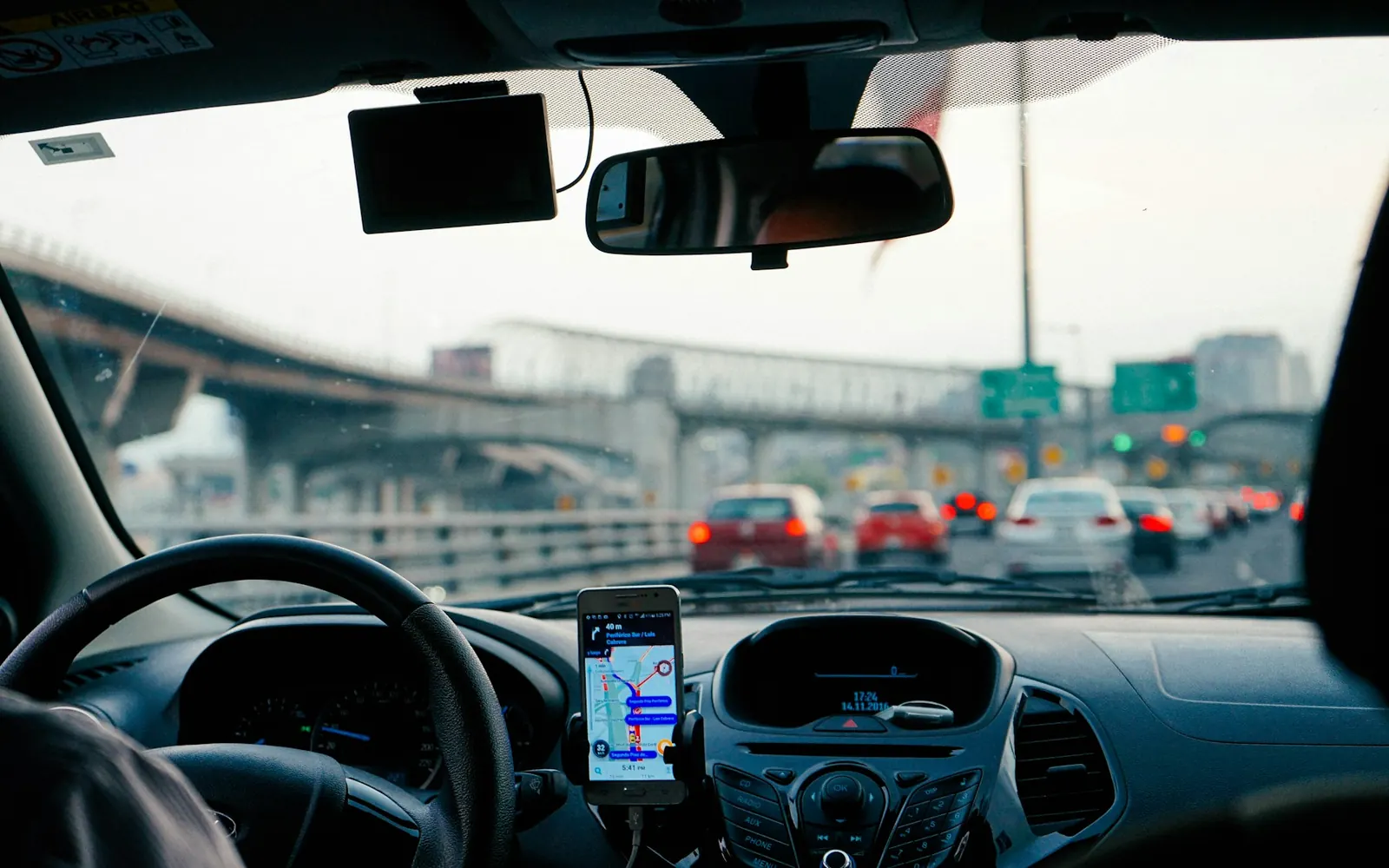 Conduite en ville avec un téléphone posé sur le tableau de bord, pendant une mission suivie au dispatch