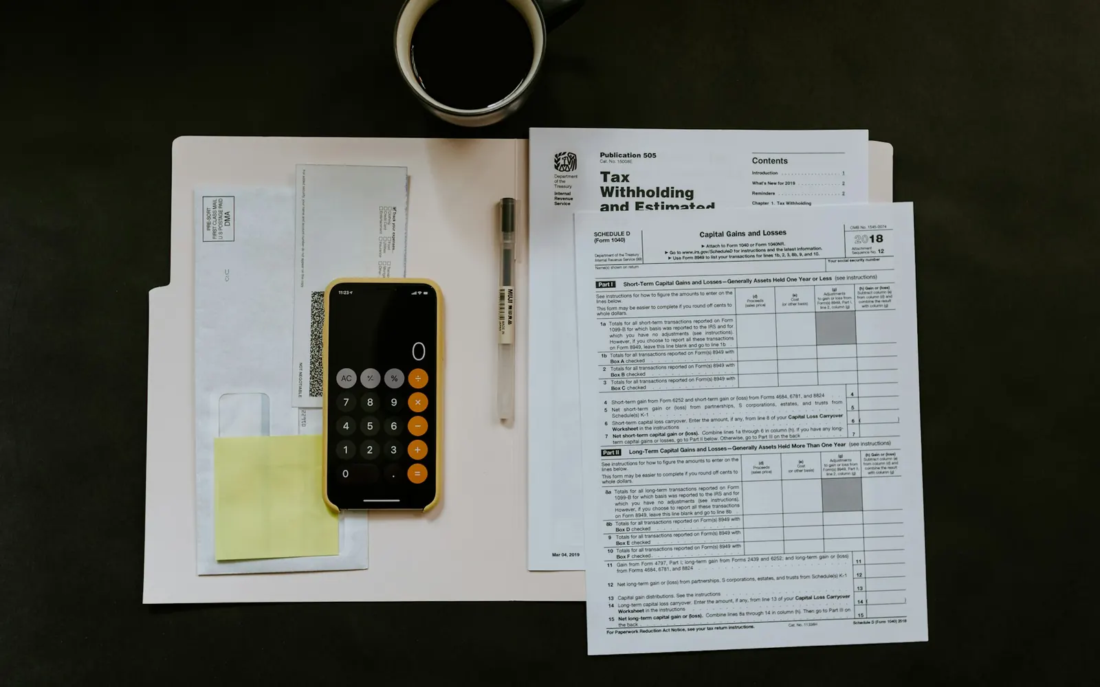 Factures papier et calculatrice sur un bureau, avant le passage à un logiciel de facturation