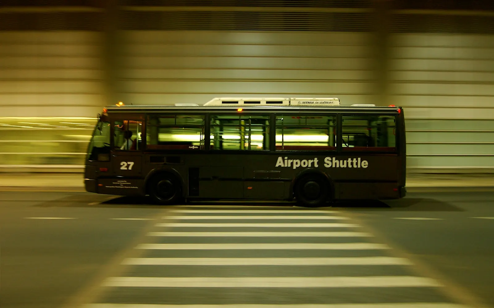 Navette aéroport de nuit devant un terminal, ligne régulière privée