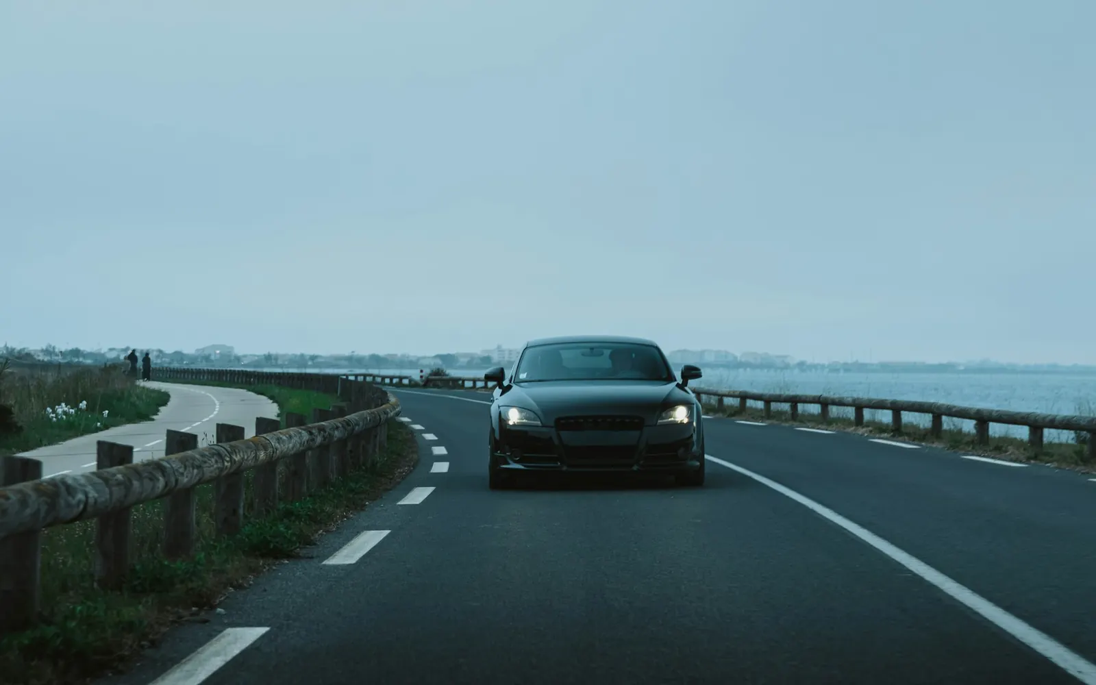 Voiture sur une route côtière, trajet aller simple vers une ville voisine avant un retour à vide