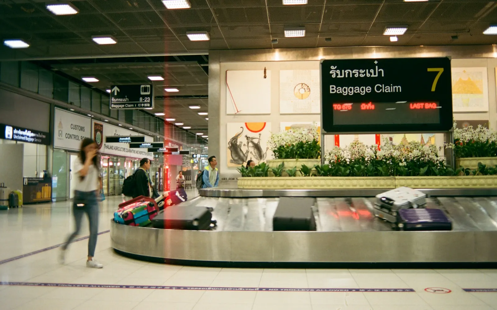 Tapis à bagages dans un aéroport, où les voyageurs récupèrent leurs valises avant le transfert
